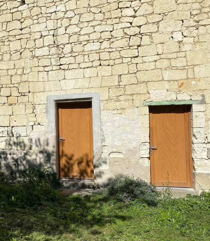 Deux portes extérieures en bois installées sur une façade en pierre par MVS 86