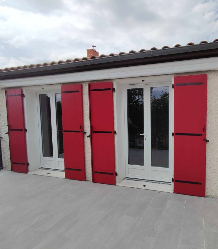 Portes-fenêtres blanches avec volets battants rouges installées par MVS 86