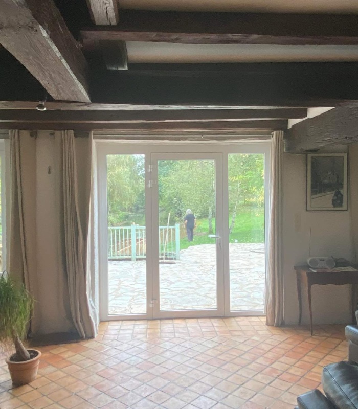 Porte-fenêtre vitrée blanche avec deux parties fixes installée par MVS 86
