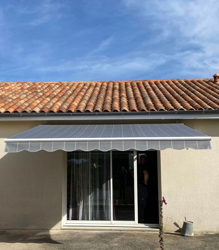 Store banne gris installé au-dessus d’une baie vitrée par MVS 86